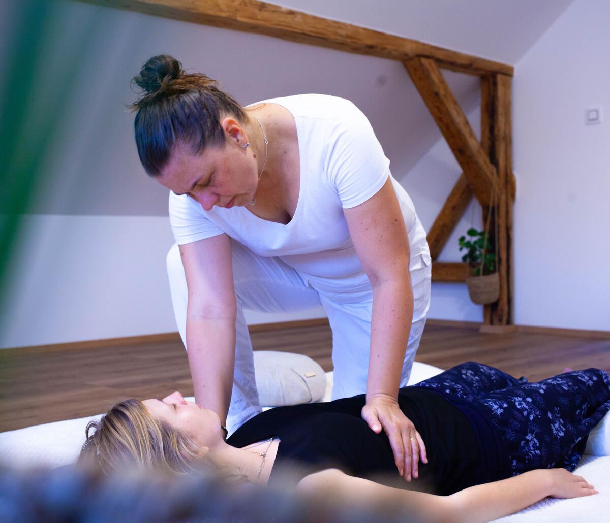 Shiatsu masáž jater - tlak dlaní Polocelek terapeuta a klientky při masáži. Uvolnění napětí v páteři a rozvolnění stresu.