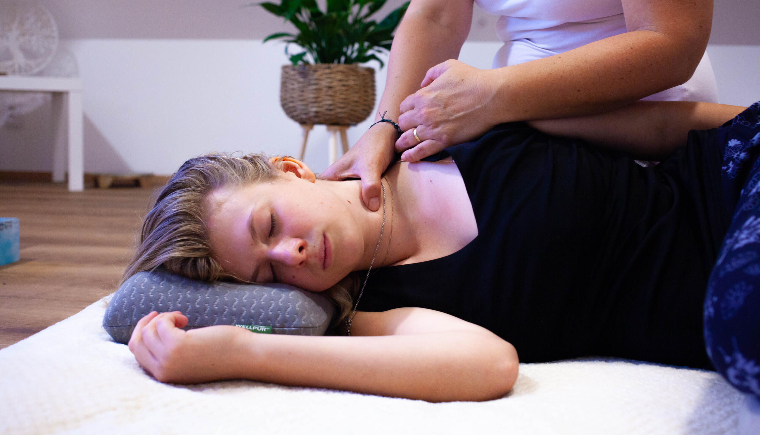 Detail na klienta při masáži krku. Terapeut odhaluje problémy pomocí hmatových technik, tímto způsobem zjistí která část těla potřebuje nejvyšší péči.