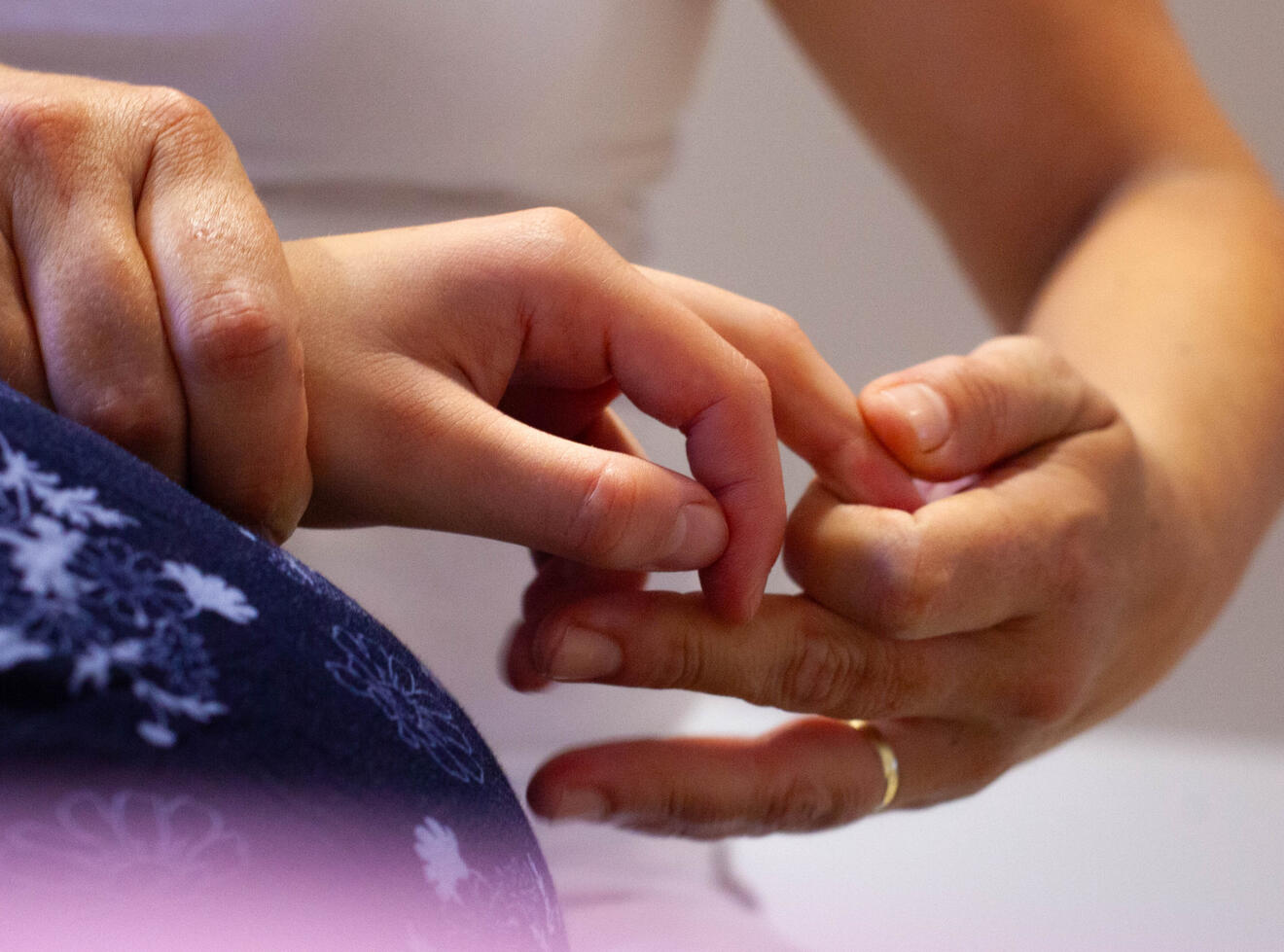 Detail terapeuta provádějícího shiatsu masáž rukou. Technika pomáhá uvolnit napětí, zlepšit průtok energie a podpořit hlubokou relaxaci klienta.